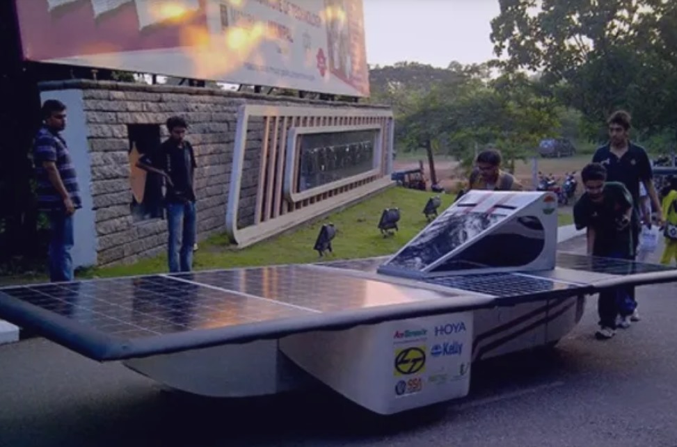 FREYR solar race car prototype, a streamlined silver low profile vehicle with integrated solar panels along its curved upper surface.